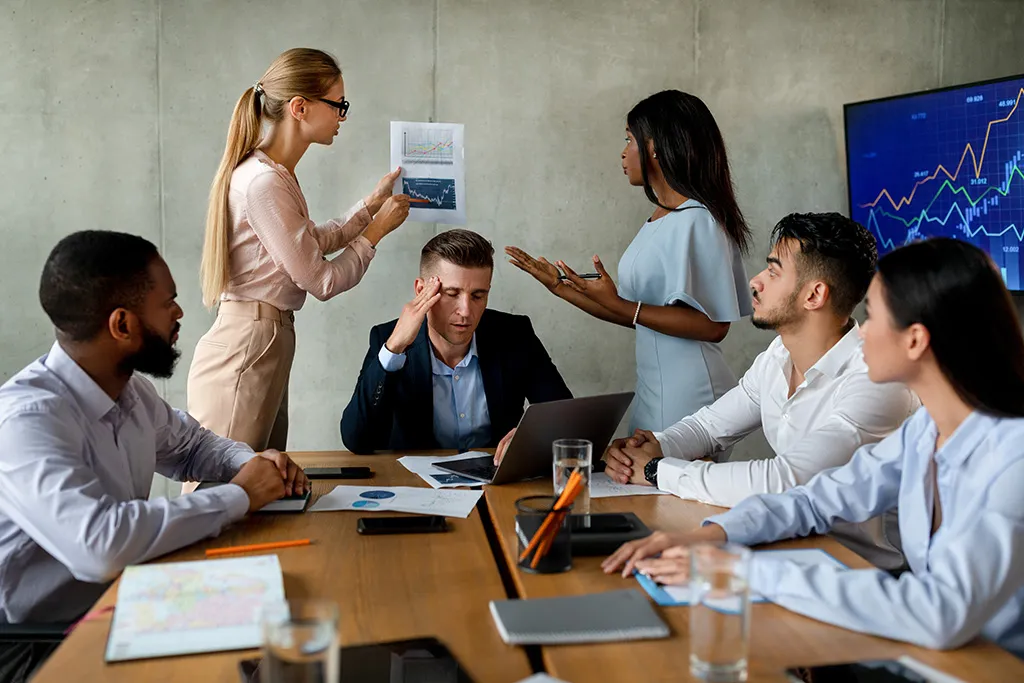 A management team in a boardroom disagreeing over conflicting performance reports.